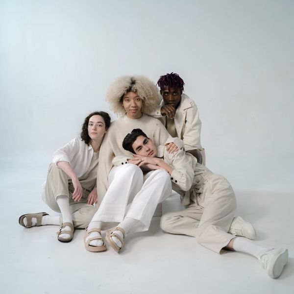 A diverse group of people sitting in a calm meditation pose in a studio.